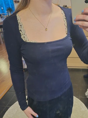 Mörkblå topp  - Mörkblå långärmad topp med fyrkantig urringning. Figurnära passform och mjukt material som känns skönt mot huden. Perfekt för dig som gillar stilrena detaljer. Köpte secondhand!!