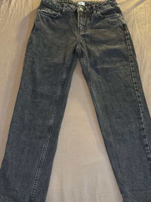 Mörkgrå raka jeans från Gina Tricot - Mörkgrå jeans från Gina Tricot i modellen Steel Loose. Jeansen har raka ben, klassisk femficksdesign och knappgylf. Perfekta för en avslappnad och trendig look.