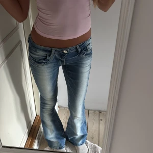 Scandi low waist bootcut jeans Gina Tricot - Säljer dessa (utsålda överallt!!) trendiga lågmidjade jeans från Gina Tricot 14+ i ljusblå tvätt med slitningar. Jeansen har låg midja,  fickor fram och bak.  Säljes pga köpt fel storlek. Dessa är stl regular (är 173 cm) så passar nog om du är under 170cm🩷 använda 2 ggr