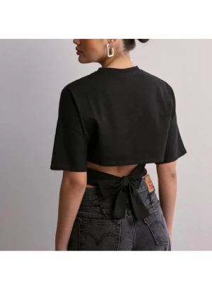 Svart croppad topp med knyt - Trendig svart croppad topp med korta ärmar och snygg knytning i ryggen. Toppen har en enkel, stilren design och är perfekt att matcha med höga jeans. Tillverkad i mjukt bomullstyg för en bekväm känsla.