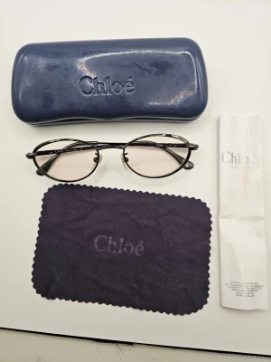 Chloé glasögon med fodral - Snygga glasögon från Chloé med metallbågar i oval form. Medföljer gör ett blått hårt fodral, putsduk och originalinstruktioner. Perfekt accessoar för en trendig look. Vet inte om dem är äkta eller inte 