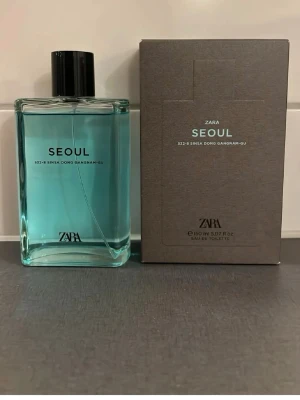 Zara Seoul Eau de Toilette 150 ml - Fräsch parfym från Zara i doften Seoul. Flaskan är rektangulär med ljusblått innehåll och svart kork. Kommer i en stilren grå kartong med minimalistisk design. Perfekt för dig som gillar moderna och rena dofter.