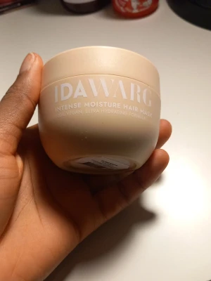 IDA WARG Intense Moisture Hair Mask - En hårinpackning från IDAWARG i en beige rund burk. Produkten är en Intense Moisture Hair Mask som är 100% vegansk och har en ultra återfuktande formula. Perfekt för dig som vill boosta hårets fukt och mjukhet.