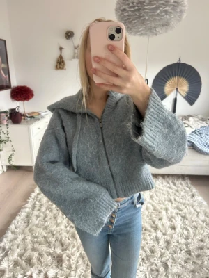 Blå stickad hoodie med dragkedja - Så mysigt, den är croppad fit. Väldigt sparsamt använd!