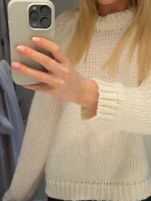 Vit stickad tröja  - Mysig vit stickad tröja med rund hals och ribbade muddar vid ärmslut och nederkant. 