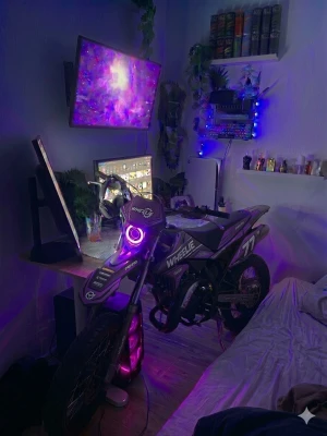 Lägg bud Säljer allt på bilden setup och moped - Säljer en svart och lila crossmoped från Wheelie med nummer 77 på sidan. Mopeden har coola neonljus runt framlyktan och sportig design med dekaler. Perfekt för dig som gillar motorer och vill ha något unikt i rummet.