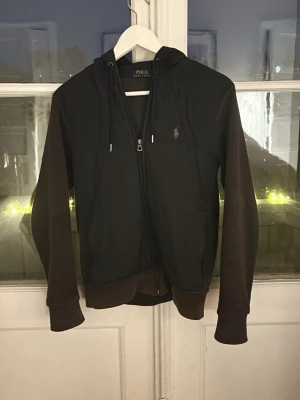 Ralph Lauren Cardigan - Säljer denna Polo Ralph Lauren Cardigan i storlek XS-S! Perfekt nu till våren/sommaren vid lite kyligare väder! Har 1 defekt som man ser på bild 4 på armen men verkligen inget som syns! Sparsamt använd. Köpt här i Stockholm för 2999kr! Äkthetsverifiering finns på bild 7. Hör av er vid frågor! Priset är inte hugget i sten och vid snabb affär ännu billigare! 🍾🔥💯