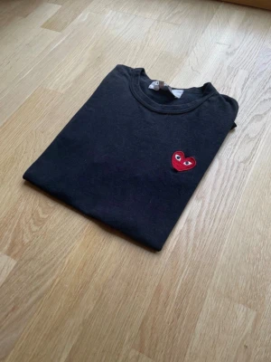 Svart t-shirt Comme des Garçons PLAY - Snygg Svart Comme des Garçons Play t-shirt i storlek S. Nypris ca 900kr mitt pris endast 299kr. Fraktar inom 1 dag, om du har någon fundering så är det bara att höra av sig😊