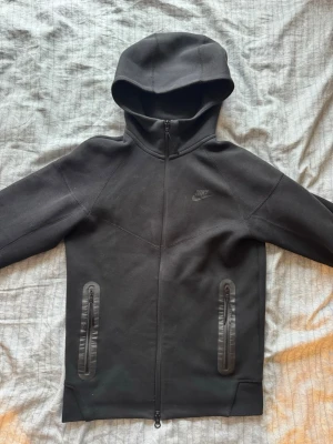 Nike tech hoodie - En svart Nike tech hoodie. Tror det är tredje generationens Nike tech. Den är i mycket bra skick och storlek Xs. Den är köpt från Nike officiella hemsida.