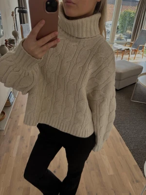 Beige kabelstickad polotröja - Mysig beige kabelstickad polotröja med bred polokrage och avslappnad passform. Stolen M men passar S också 