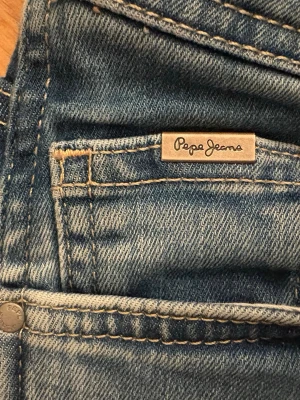 Blå jeans från Pepe Jeans Power Flex - Säljer ett par ljusblå jeans från Pepe Jeans, modellen Power Flex. Jeansen har klassisk femficksdesign, normal midja och smal passform. Materialet är stretchigt för extra komfort och rörelsefrihet. Snygga slitningar och detaljerade sömmar ger en trendig look.