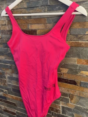 Rosa baddräkt från Calvin Klein - Snygg rosa baddräkt från Calvin Klein med breda axelband och rundad urringning. Tillverkad i stretchigt material som sitter bekvämt på kroppen. Diskret logga i svart på sidan. Perfekt för strand eller poolhäng.❤️Använd vid ett tillfälle 