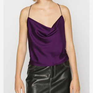 Lila festtopp från Monki - Säljer en lila festtopp från Monki i satinmaterial. Storlek S, endast använd en gång!