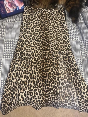 Leopardmönstrad kjol från H&M - Säljer en snygg leopardmönstrad kjol från H&M. Kjolen är i ett mjukt, lätt material och har en rak passform med dragkedja i sidan. Perfekt för dig som vill sticka ut med ett djurmönster i beige, svart och brunt.