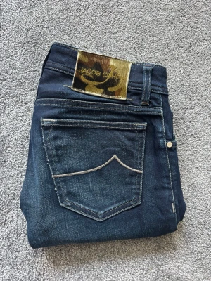 Jacob Cohen Jeans Marinblå W31 - Hej 👋  Jag säljer mina extremt välvårdade Jacob Cohen-Jeans i en mörk marinblå färg med naturliga slitningar. 💫😍 Säljer jeansen vid detta pris pågrund av väldigt kort tids användning.  Säljer av anledning att jeansen blivit för må för mig🥲  Ordinarie pris: 5 299kr Produkten finns även på annan plattform— så först till kvarn som gäller😉  Tveka inte över att skriva vid frågor eller funderingar😄