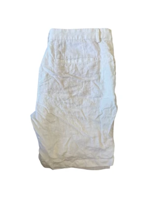Vita linneshorts med fickor från ZARA - Snygga vita shorts i linne med klassisk passform. De har bälteshällor, sidofickor och en bakficka för en clean look. Perfekta för varma dagar och ger en avslappnad men stilren vibe.
