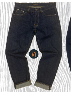 Dry Selvage Nudie Jeans Nyskick* - Ett par riktigt snygga nudie jeans i modellen GRITTY JACKSON Dry Selvage, med en rak passform och japansk selvage denim. Jeansen har inga tecken på användning eller defekter, som  de är sprillans nya🤩 Jag ser en sjuk potential för tydliga och asfeta fades för en skön stil✌️101 cm i längd, W31 L30👍. Du får chansen att köpa ett par riktigt feta jeans i japansk denim, som lär hålla och slitas med dig i många år🤩 Man kan se det som en investering🤝. Nypris - 2500kr, Mitt pris - 1499kr✅