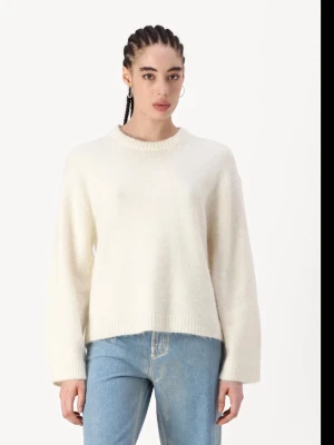 Krämvit stickad tröja med rund hals - Mysig krämvit stickad tröja med avslappnad passform och rund halsringning. Tröjan har långa ärmar och ribbade muddar vid ärmslut och nederkant. Perfekt att styla med jeans för en enkel och clean look.