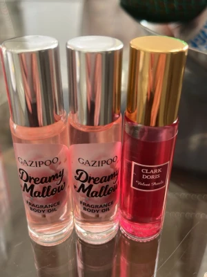 Parfymoljor Gazipoo & Clark Doris - Tre parfymoljor i smidiga glasflaskor med metallock. Två från Gazipoo i doften Dreamy Mallow med silverfärgat lock och ljusrosa olja, samt en från Clark Doris Velvet Petals med guldlock och djuprosa olja. Perfekta att ha i väskan för en fräsch doft när som helst.