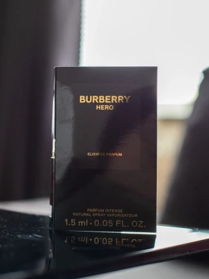 Burberry Hero Elixir de Parfum 1,5 ml - Burberry Hero Elixir de Parfum i en elegant svart och guld kartong. Innehåller en liten sprayflaska på 1,5 ml med intensiv doft. Perfekt som prov eller att ha med sig i väskan. Flaskan är genomskinlig med svart sprayhuvud.