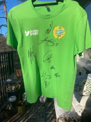  Hammarby t-shirt med autografer - En Hammarby tröja med autografer från topp spelare från säsongen 23/24 med spelare som Yousef Erabi, Nahir Besara och Oliver dovin