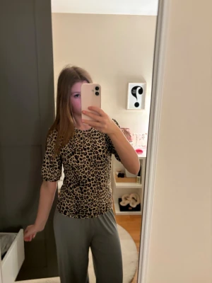 Leopardmönstrad t-shirt - Snygg t-shirt med leopardmönster i beige, svart och brunt. Modellen har rund halsringning och korta ärmar. Perfekt för dig som gillar leopardmönster. Har använt den en gång. Priset kan diskuteras ❣️