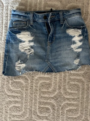 Blå jeanskjol från Holister - Säljer en kort blå jeanskjol som är från Holister ❤️ Storlek 23 så sitter som XS ❤️Aldrig använd! Pris kan diskuteras!