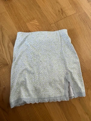 Blommig kortkjol från Ginatricot - Supersöt kortkjol från Ginatricot med ljust blommigt mönster, Kjolen har en slit framtill storlek S