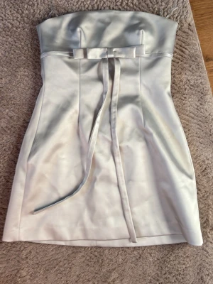 Vit axelbandslös kort klänning med rosett - Säljer denna finklänningen! Superfin nu till sommaren. Storlek M men från Zara så passar M/S