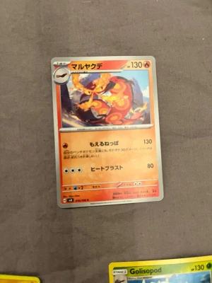 Japansk Pokémonkort Maruyakude - Säljer ett japanskt Pokémonkort med Maruyakude (Centiskorch) motiv. Kortet har en eldig design med röd och orange färg och japansk text. Perfekt för samlare eller Pokémonfans som vill utöka sin kortsamling.
