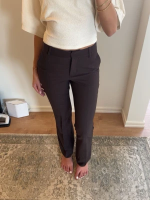 Bruna kostymbyxor från BikBok - Snygga bruna kostymbyxor från BikBok med raka ben och klassisk passform. Byxorna har hällor för skärp, två fickor fram och stängs med dragkedja och hake. Aldrig använda, nypris 599🩷