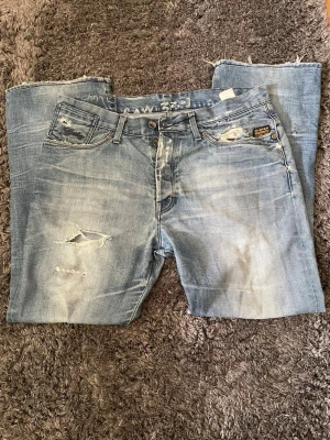 Archive raw denim jeans - Säljer ett par helt sjukt feta archive jeans i raw denim. Byxorna är unika med snygg tvätt och snygga slitningar. Passformen är straight/loose fit och jeansen har en lite bredare midja, något som enkelt kan fixas med ett bälte. Längden passar dig som är 180-188 Tveka inte att höra av dig vid frågor eller fler bilder, priset är ej hugget i sten!