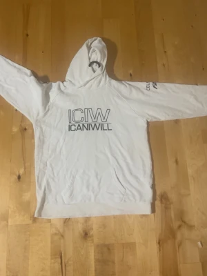Vit hoodie ICANIWILL x Celsius - Snygg vit hoodie från ICANIWILL i samarbete med Celsius. Stor logga framtill och tryck på ärmar och rygg. Klassisk känguruficka och huva. Perfekt för gymmet eller chill. Mjukt material och relaxed fit.  Kom med bud