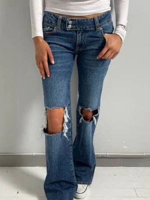 bootcut jeans med låg midja - Blå bootcut byxor med låg midja och hål i knäna. Byxorna är i väldigt bra skick och endast använda ett fåtal gånger. Hör av dig vid frågor eller fler bilder. är 160cm lång ❤️ ( första bilden är tagen från hemsidan) 