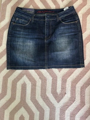 Mörkblå jeanskjol från Red Jeans - Snygg mörkblå jeanskjol från Red Jeans. Midjemåttet e 39 cm rakt över vilket motsvarar storlek S ungefär