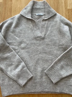 Beige stickad tröja från Chiquelle - Säljer en beige stickad tröja från Chiquelle med krage och v-ringad hals. Tröjan har långa ärmar och breda ribbade muddar vid ärmslut och nederkant. enkel att matcha till olika outfits.