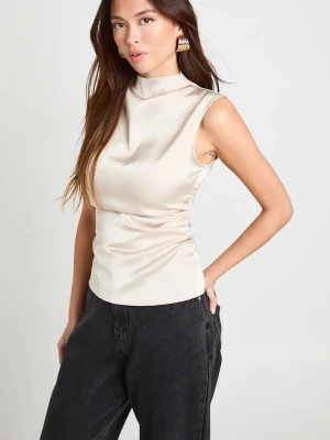 Cremevit satintopp - Snygg ärmlös topp i cremevit satin-look. Toppen har hög krage och figurnära passform som ger en clean och modern vibe. Perfekt att styla med både jeans och kjol för en trendig look.