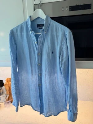 linneskjorta från Polo Ralph Lauren - Säljer en ljusblå skjorta från Polo Ralph Lauren i linne, storlek S men sitter som S/M 