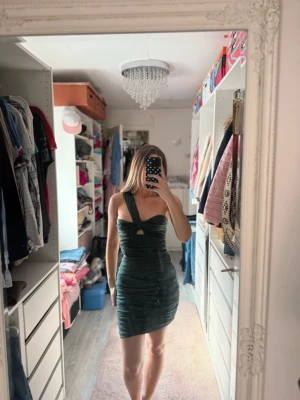 Mörkgrön one shoulder kort klänning - Superfin mörkgrön kort klänning med one shoulder och snygg cut-out framtill🩷
