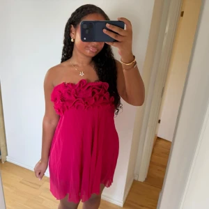 MörkRosa volangklänning från zara - Säljer denna jättefina axelbandslösa klänningen från zara. Den är mörkrosa med volanger upptill. Säljs inte på zara längre 💘