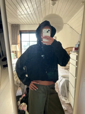 Svart croppad hoodie - Säljer en svart croppad hoodie med luva och långa ärmar. Hoodien har en enkel och clean look utan synliga loggor eller tryck. Perfekt för en chill och avslappnad stil. Materialet känns mjukt och bekvämt.