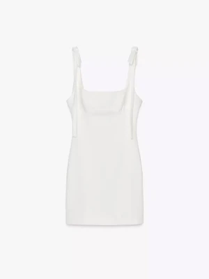 Vit kort klänning med rosetter - Perfekt till studenten om man ska bli sprayad med champagne och vill ha en billig klänning man inte bryr sig om. Hade den till mitt utspring så det finns fläckar (bild 3 & 4) men de syns inte supermycket. Köpt för 380kr. 