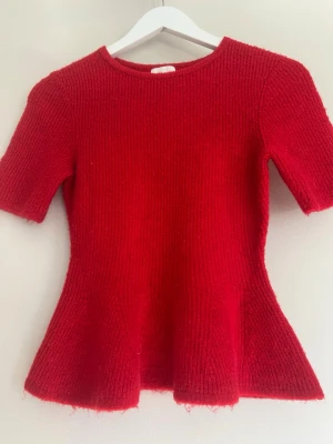 Röd stickad topp med volanger i midjan från Hm - Säljer denna röda stickade toppen med volanger i midjan från Hm i storlek S. Endast använd två ggr så den är i nyskick skulle jag säga! 