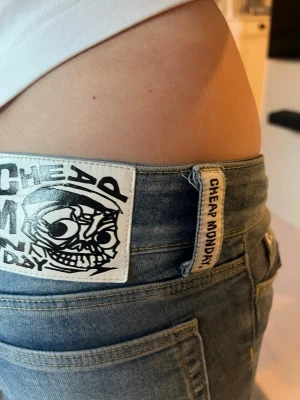 Blå bootcut jeans från Cheap Monday - Säljer ett par blå bootcut jeans från Cheap Monday med ikonisk logga bak på linningen. Jeansen har en klassisk femficksmodell och är tillverkade i denim med lätt tvättad look. Perfekta för dig som gillar en avslappnad men trendig stil. Storlek 27/30
