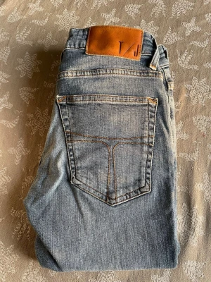 Tiger of Sweden - Säljer ett par feta Tiger of Sweden jeans i storlek 27/32 för en stilren look . Klassisk tvätt som passar till det mesta och ger en snygg, tidlös look. Jeansen är i fint skick utan hål eller större slitage. Hör av dig vid frågor eller för fler bilder!