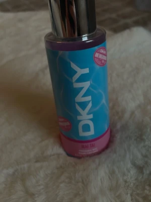 DKNY Mai Tai Fragrance Mist 250ml - Fräsch och tropisk body mist från DKNY i doften Mai Tai. Flaskan är blå med rosa detaljer och har ett silvrigt lock. Perfekt för dig som vill ha en lätt och somrig parfym med exotiska vibbar. Innehåller 250 ml.