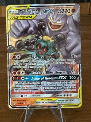 Pokémonkort Marshadow & Machamp GX - Säljer ett Pokémonkort med Marshadow & Machamp GX TAG TEAM från Sun & Moon-serien. Kortet har färgstark design med guld, svart och blå detaljer och är gjort av glansigt papp. Perfekt för samlare eller dig som vill boosta din lek med en kraftfull GX-kombination.