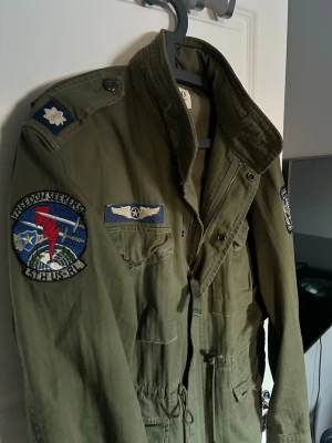 Grön militärinspirerad jacka med patchar - Säljer en grön field jacket från Ralph Lauren i storlek L, 10/10 skick på jackan och otroligt snygg och perfekt att styla, 2999:- går att få med en passande hoodie om man är smidig. Mvh/ Gardefashion 