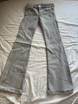 Gråa bootcut jeans med utsvängda ben - Snygga ljusgrå jeans med bootcut och utsvängda ben. Jeansen har en modern passform och är tillverkade i mjukt denimtyg som ger en skön känsla. 