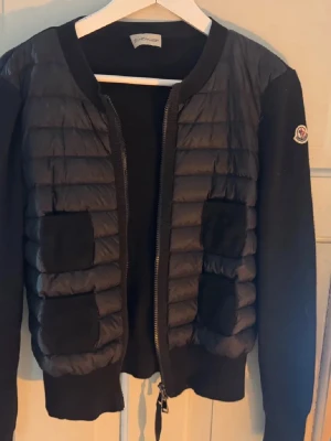 Svart Moncler cardigan  - Jättesnygg svart moncler cardigan i mycket fint skick. Äktighetsbevis finns. Hör av er för fler bilder eller frågor. Priset är diskuterbart. 
